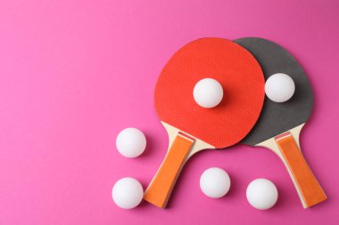 Pembe arka planda tenis raketi ve top, yakın plan. spor oyunu