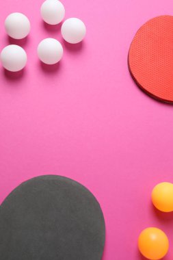 Masa tenisi ve pembe ve mavi kağıt üzerinde topları olan masa tenisi raketleri.