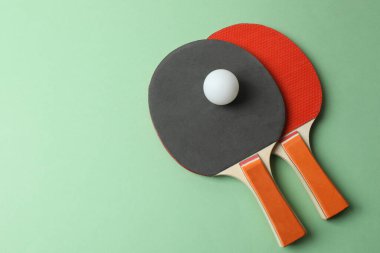 Gri masadaki pong raketi ve toplarının üst görünümü