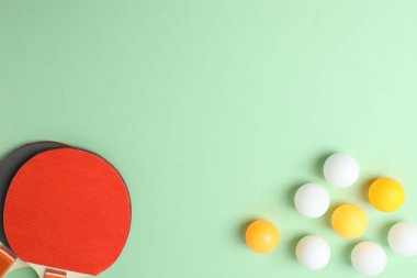 Tenis raketleri ve toplar masada.