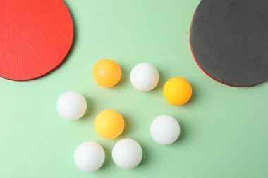Masa tenisi topları ve sarı arka planda raket. düz yat