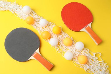 masa tenisi seti ve toplar sarı arkaplanda