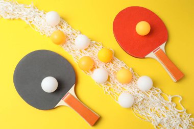 Renkli arka planda tenis topları ve raketler