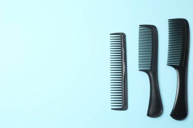 Mavi arka planda farklı saç fırçaları, düz yatış. Metin için boşluk