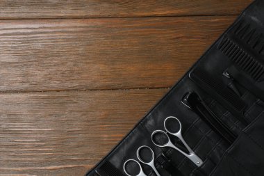 Koyu ahşap arka planda kuaför aletleri.