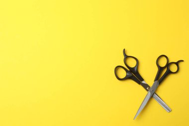 Renk arkaplanı üzerinde makas ve tarak, metin için boşluk. Kuaför salonu.