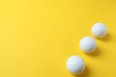 Sarı zemin üzerinde beyaz golf topu.