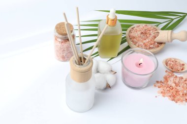 Beyaz arkaplanda kozmetik ürünleri ve mumlarla kompozisyon