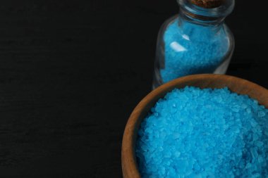 Siyah arka planda tuz ve mavi cam kase.