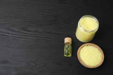 Bir şişe hindistan cevizi yağı ve gri masadaki vücut malzemeleri.