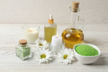 Tahta masadaki taze çiçeklerle birlikte gerekli yağlar.