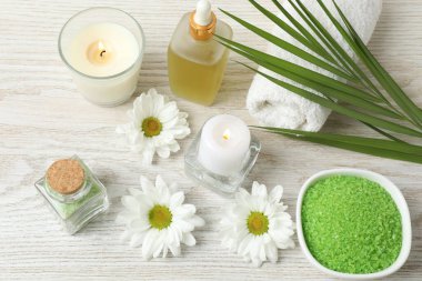 Çiçekli spa kompozisyonu ve ahşap arka planda yeşil yapraklar