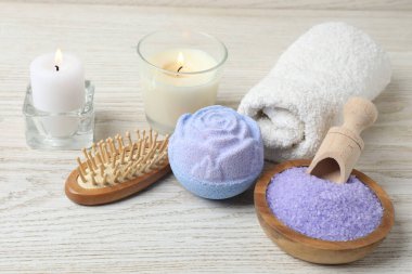 Lavantalı banyo aksesuarları, havlular, ahşap arka planda mumlar.