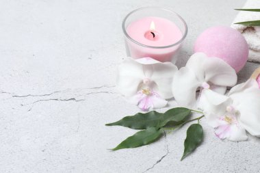 Güzel mumlar, orkide çiçekleri, gri mermer arka plan, üst manzara.