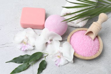 Spa ve doğal tedavi konsepti. Doğal sabun pembe gül, havlu, tuz, sabun, banyo tuzu ve beyaz mermer arka planda vücut fırçası.