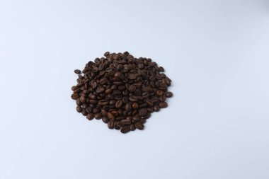 Kavrulmuş kahve çekirdekleri, beyaz arka planda izole edilmiş.
