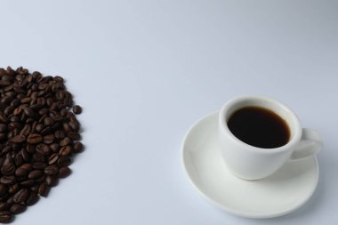 Beyaz arka planda kızarmış fasulyeli bir fincan kahve.