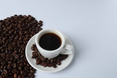 beyaz zemin üzerine kahve çekirdekleri ile kahve Kupası.
