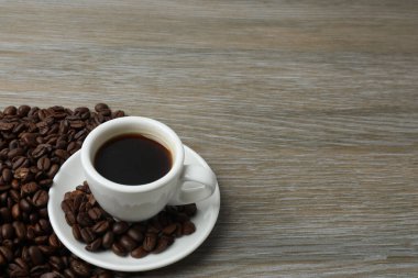 Kahve fincanı ve kahve çekirdekleri ahşap arka planda. Kahve çekirdekleri.