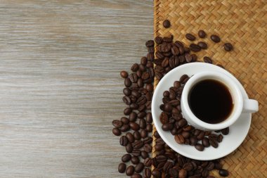 ahşap zemin üzerinde kahve çekirdekleri ile kahve