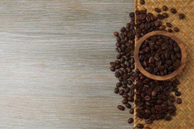 Tahta bir arka planda kaşık olan kahve çekirdeğinin üst görüntüsü.