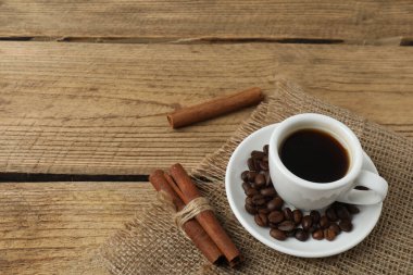ahşap masa üstünde kahve çekirdekleri ile kahve Kupası