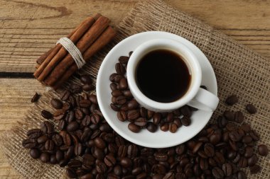 Kahve çekirdekleri, kahve fincanı ve tarçın çubuğu..