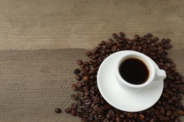 Tahta arka planda bir fincan kahvenin üst görüntüsü..