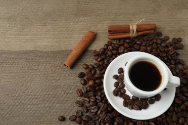 Kahve çekirdekli sade kahve, tarçın çubukları ve ahşap arka planda anason.