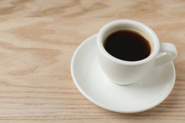 Kahve fincanı ve kahve ahşap arka planda.