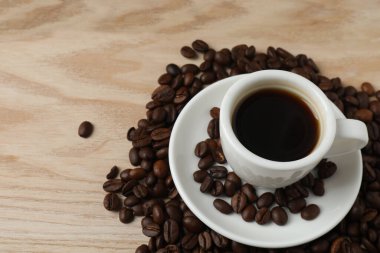 Bir kupa kahve ve bir fincan kahve, ahşap masanın üstünde..