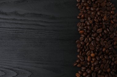 Ahşap arka planda kahve çekirdekleri ve metin için fotokopi alanı. kahve çekirdekleri masada..