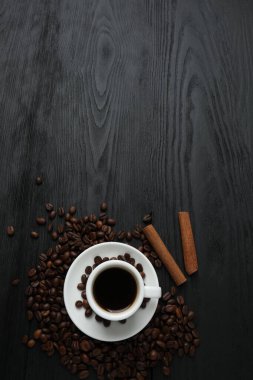 Tahta masada bir fincan kahve ve fasulye.