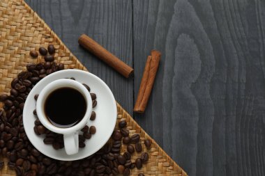 Ahşap arka planda tarçın çubuklu bir fincan kahve. Düz yat. Metin için boşluk.