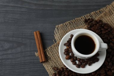 Ahşap arka planda bir fincan kahve ve fasulye. Üst Manzara. Boşluğu kopyala