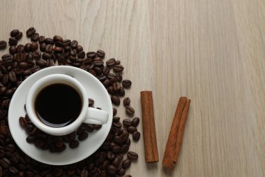 Bir fincan sade kahve, kahve çekirdeği ve ahşap bir yüzeye anason. en üstteki görünüm.
