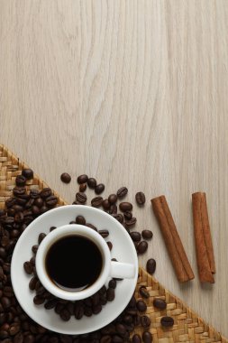 Kahve çekirdekleri, kahve fincanı ve ahşap masada. en üstteki görünüm