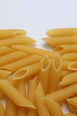 Beyaz arka plan üzerinde pişmemiş Penne makarna.