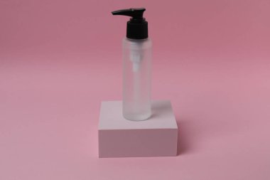 Pembe arka planda petrollü bir şişe serum ya da damlatıcı.