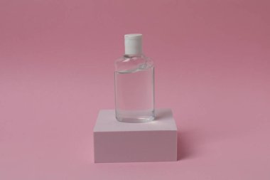 Pembe arka planda bir şişe su