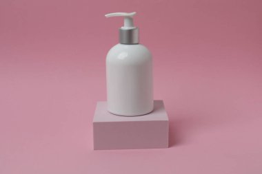 Pembe arka planda beyaz kozmetik şişe. Boşluğu kopyala.