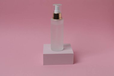 Pembe arka planda gölgeli parfüm şişesi