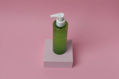 Yeşil zemin üzerinde boş bir şişe sıvı ya da sabun