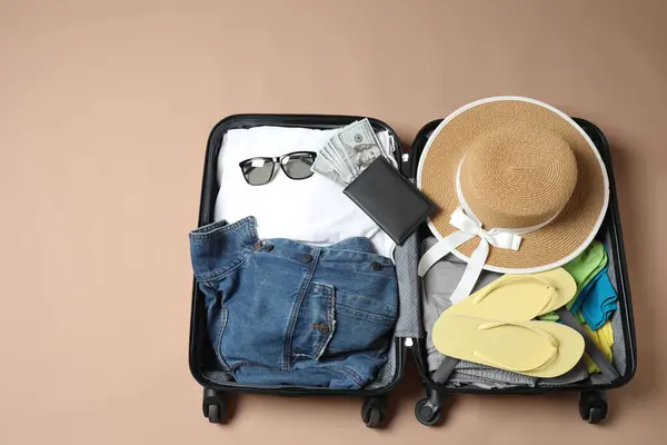 Hafif ahşap arka planda seyahat çantası olan düz bir kompozisyon. yaz tatili