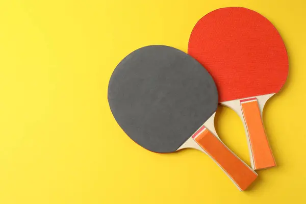 Tenis raketi ve top sarı arka planda. Spor konsepti. düz yat.