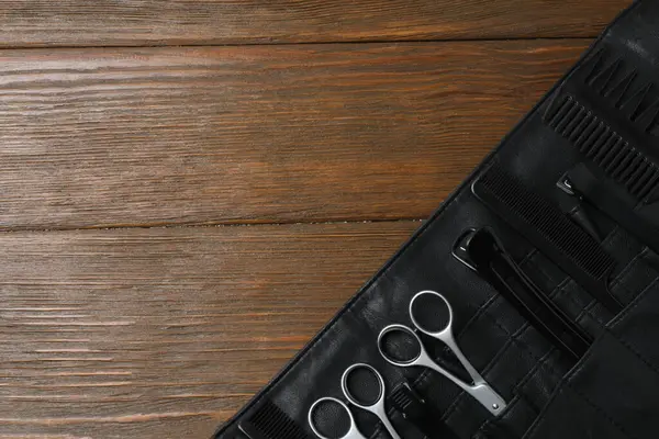 Koyu ahşap arka planda kuaför aletleri.