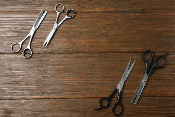 Ahşap arka planda profesyonel kuaför makası ve makas.