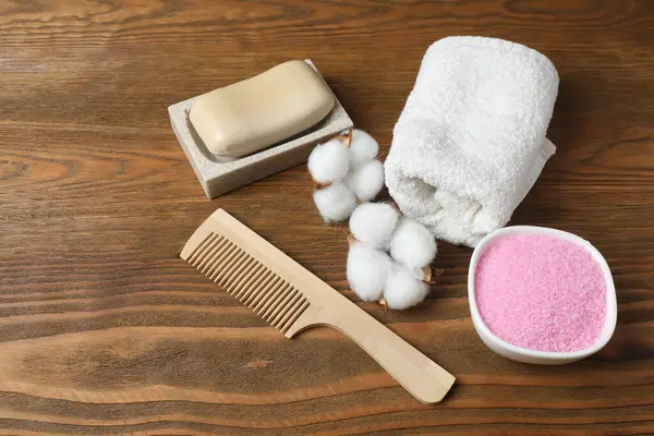 Ahşap arka planda havlular ve aksesuarlarla spa kompozisyonu