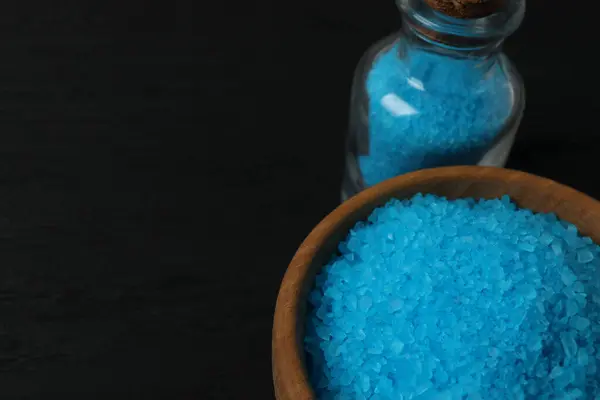 Siyah arka planda tuz ve mavi cam kase.