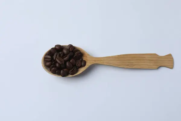 tahta kaşıkla kahve çekirdekleri beyaz zemin üzerine izole